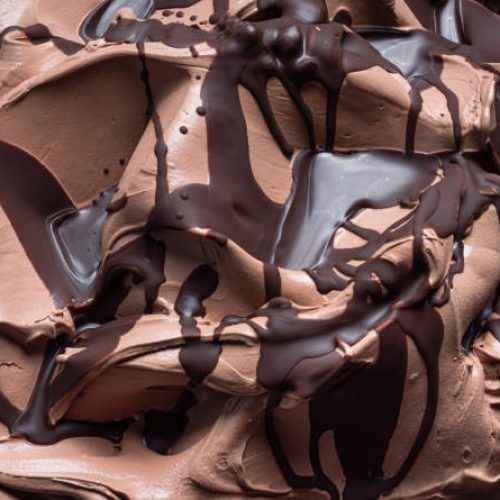 Chocolate flavour gelato - full frame detail. Close up of a brown surface texture of chocolate Ice cream covered with dark chocolate topping.